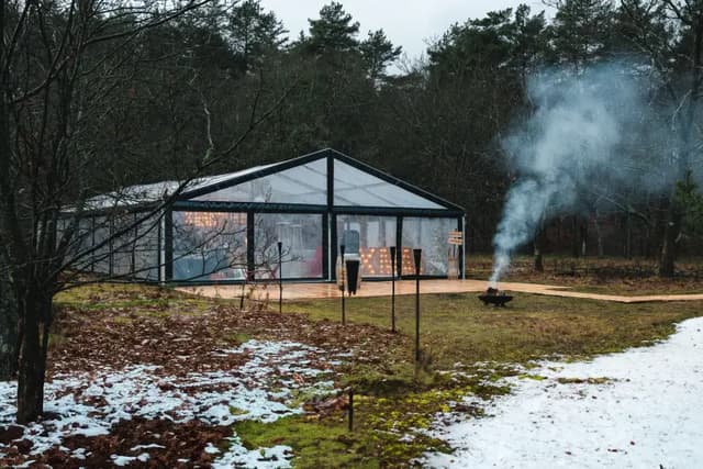 De kastent van de Après Ski Hideout in een besneeuwd bos