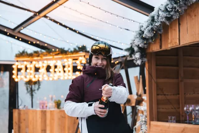 Gast proost met een fles bij de cocktailbar
