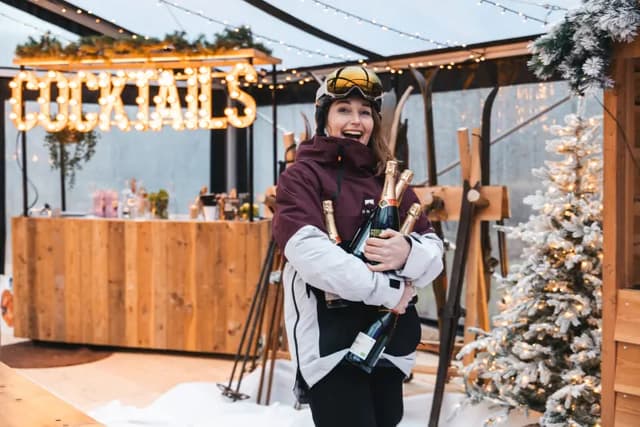 Gast met ski's en een fles bij de cocktailbar