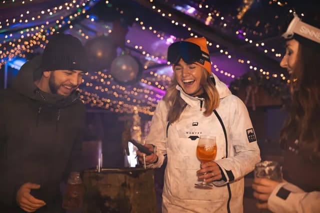 Gasten proosten onder de feestverlichting