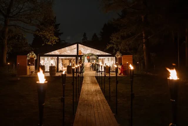 Fakkelpad door het bos naar de verlichte kas van de Christmas Hideout