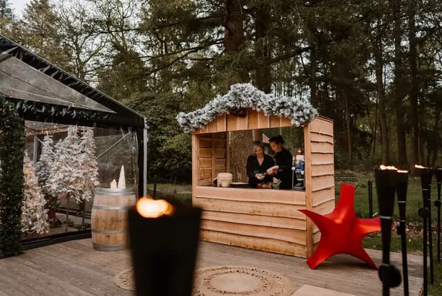 Houten kersthuisje met rode ster op het terras van de Christmas Hideout