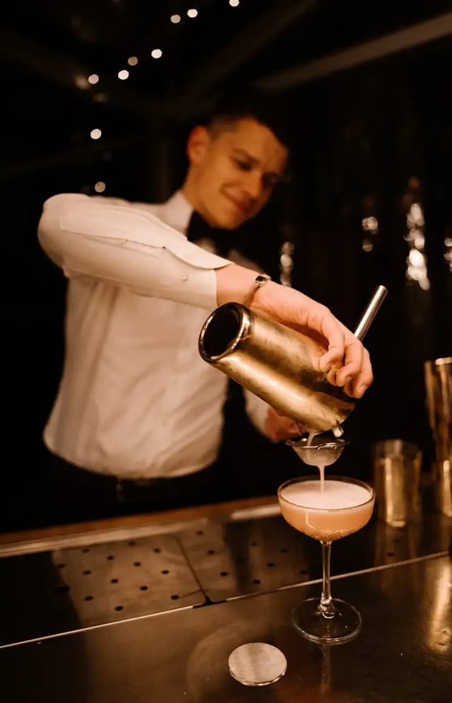 Bartender schenkt een cocktail in